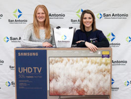 SACFCU's Bill Pay Contest Winner. Picture of the office manager and the winner with a 50 inch TV!
