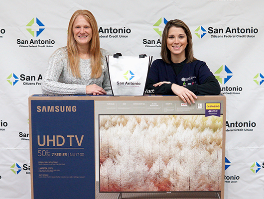 SACFCU's Bill Pay Contest Winner. Picture of the office manager and the winner with a 50 inch TV!