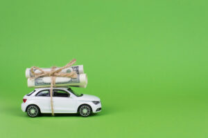 picture of a toy car with rolled up money tied to the roof.