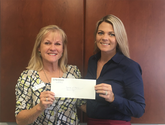 Picture of SACFCU Employee handing over the donations collected for Denim Day Week