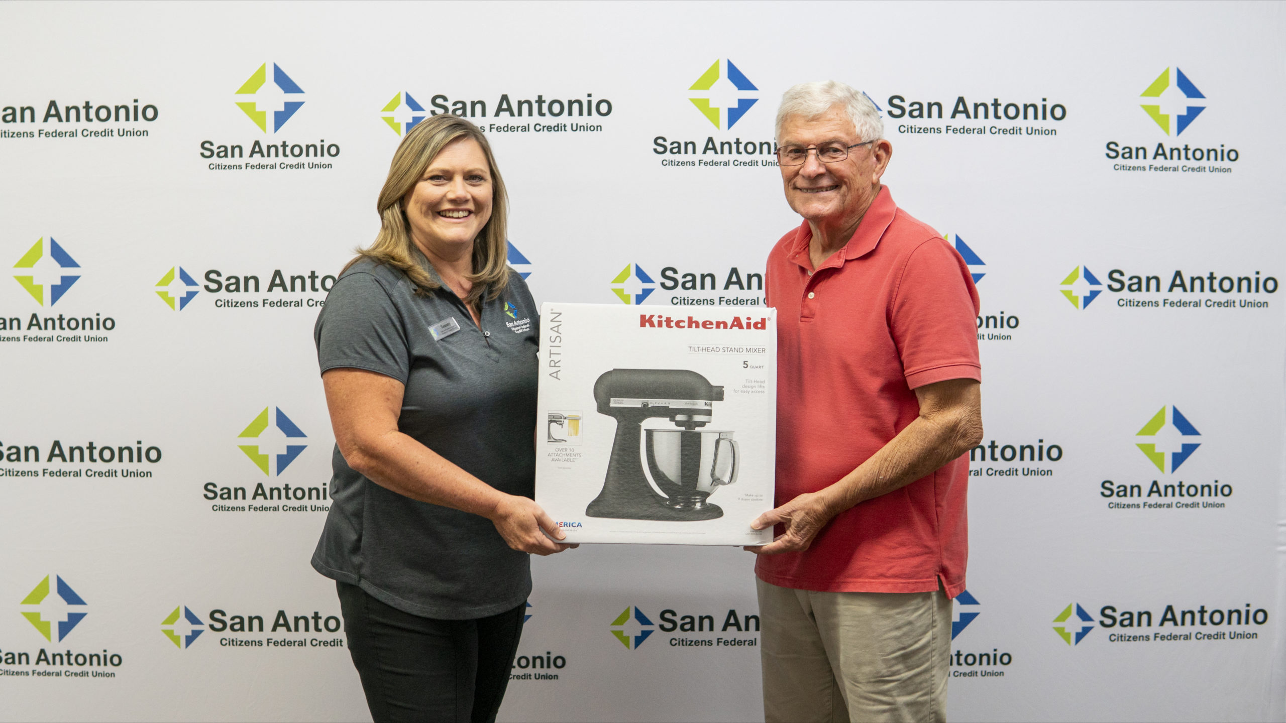 Picture of the Dade City Branch Manager along with the winner of SACFCU's Mobile Banking Contest. Both of them are holding up the price of a Kitchenaid Stand Mixer